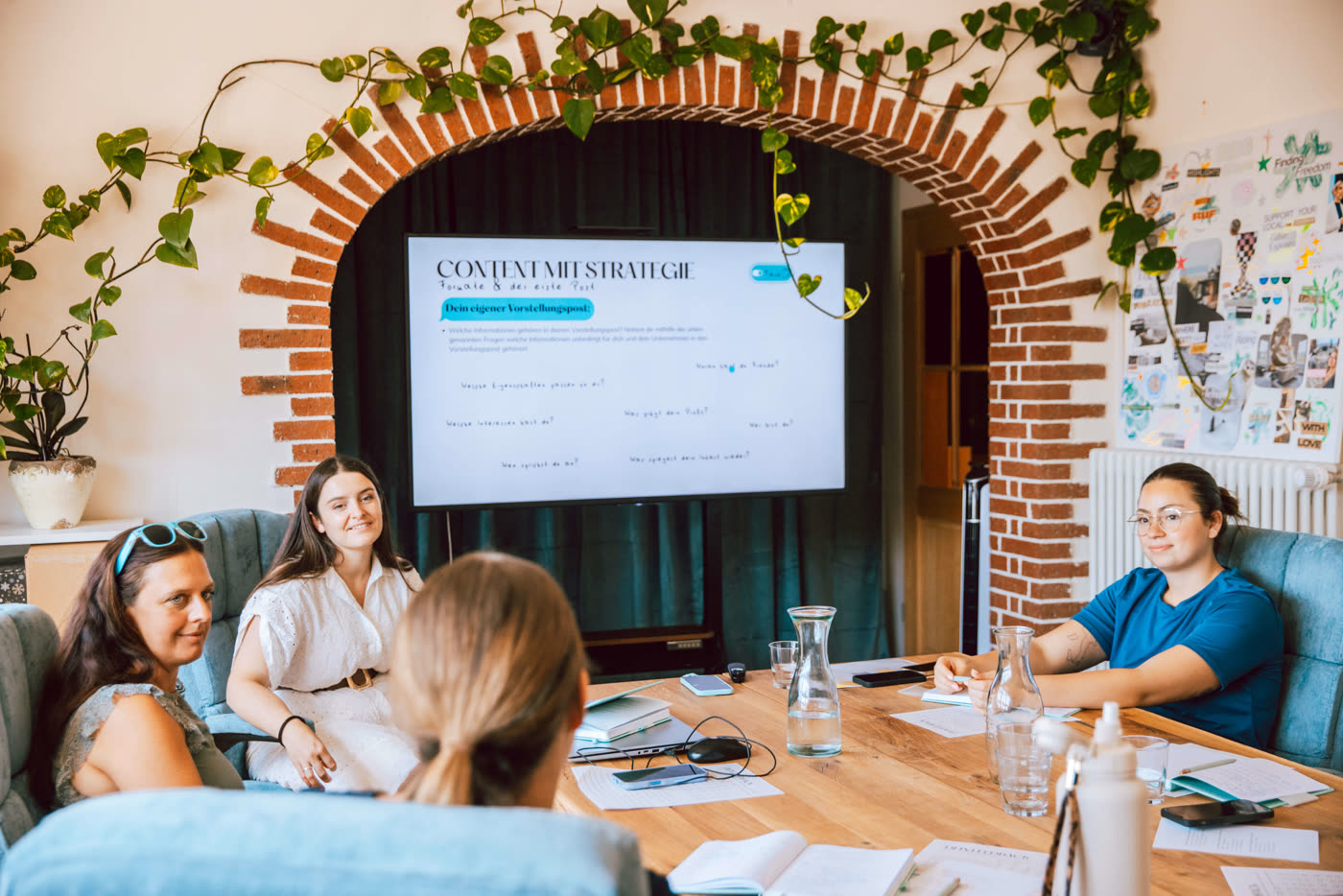 Gruppe am Tisch vor der Folie „Content mit Strategie“ im PAC Haus